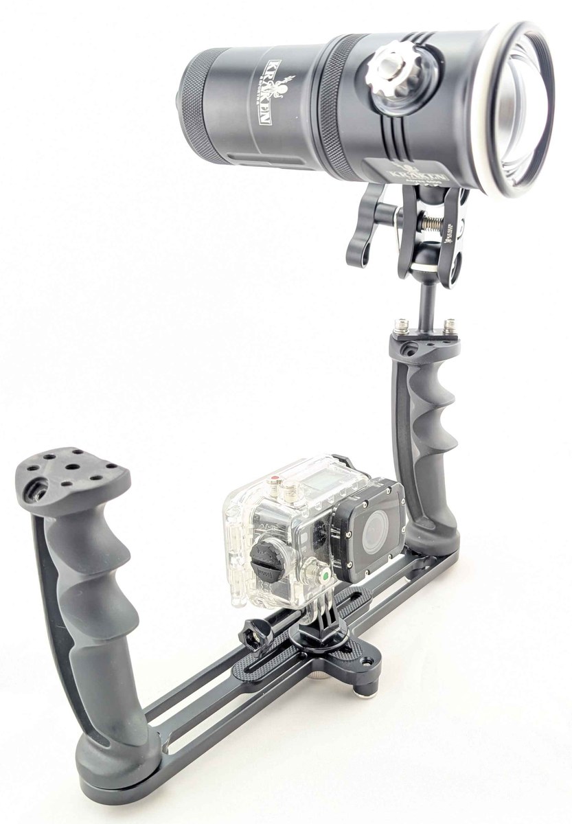 Single-light action-camera rig with a dual-handle tray, compact ball-to-YS arm and clamp, and camera in a clear housing.